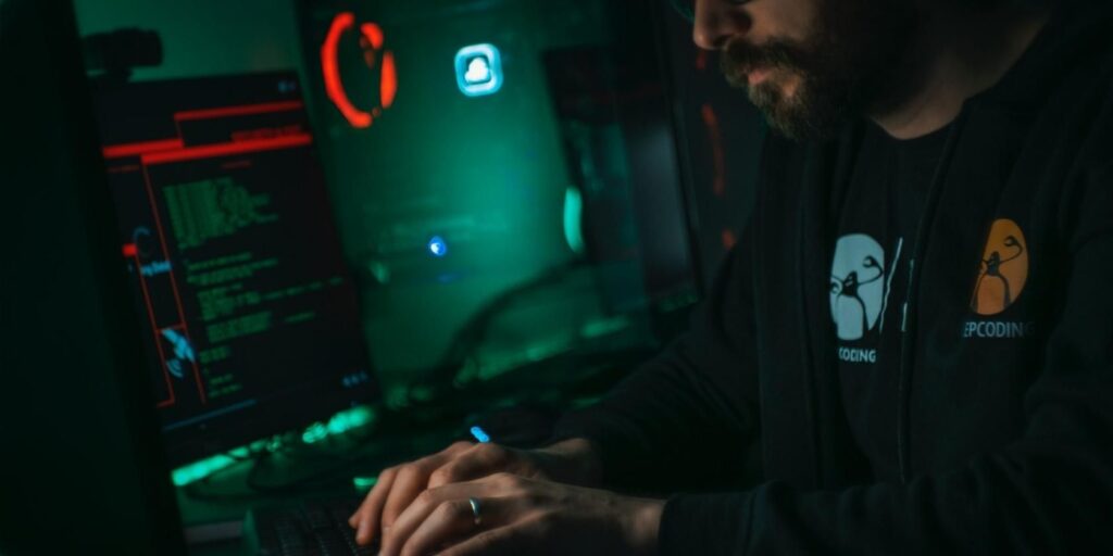 man working on a computer in dark